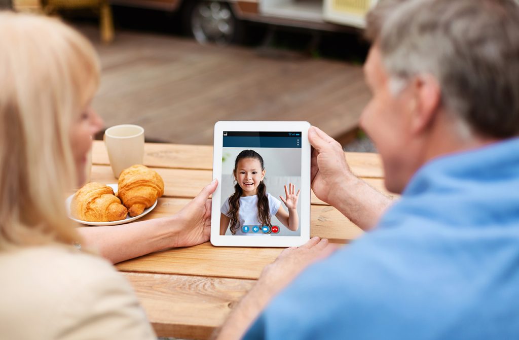 grandparents making video call with kid using tablet