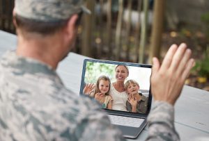 shot of a soldier on a video call with his family outside.